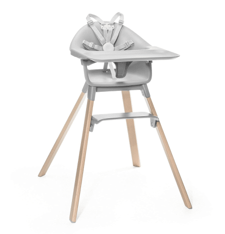 Stokke Clikk High Chair in gray with wooden legs, detachable tray, and 5-point harness for safe baby feeding.